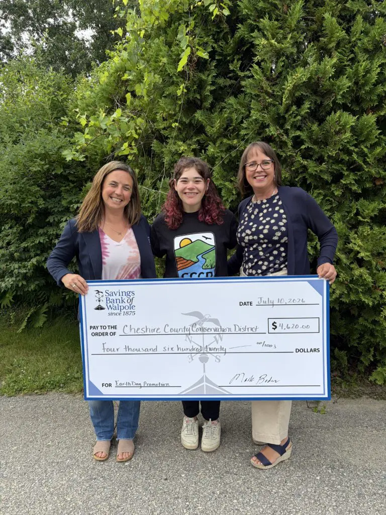 Danielle Ruffo (l) and Heather Ferlund (r) of Savings Bank of Walpole, present a check for $4,620 to Benée Herston (c), District Manager of the Cheshire County Conservation District. The funds were raised by SBW customers during the bank’s Earth Day eStatements promotion.
